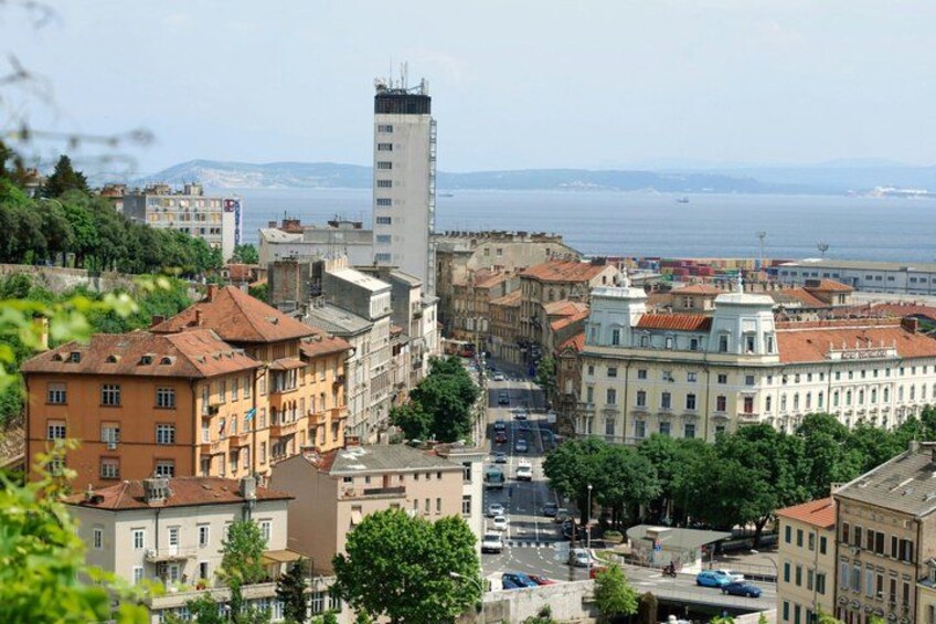 A cityscape with a prominent tall building, a river in the background, and a mix of historic and modern architecture. 3