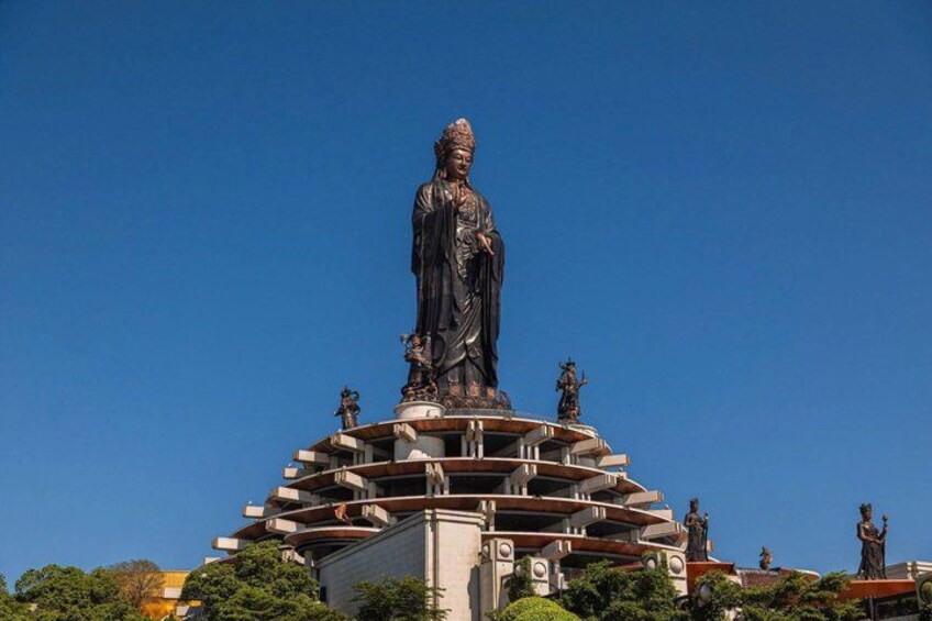 A large statue on a multi-tiered pedestal with smaller statues around it. 5