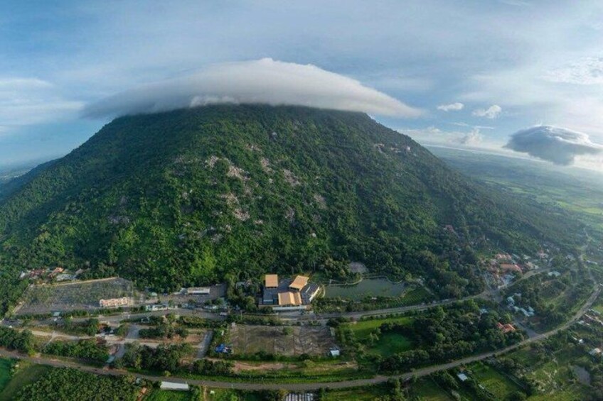 A mountainous landscape with a village at its base, surrounded by greenery and a river. 2
