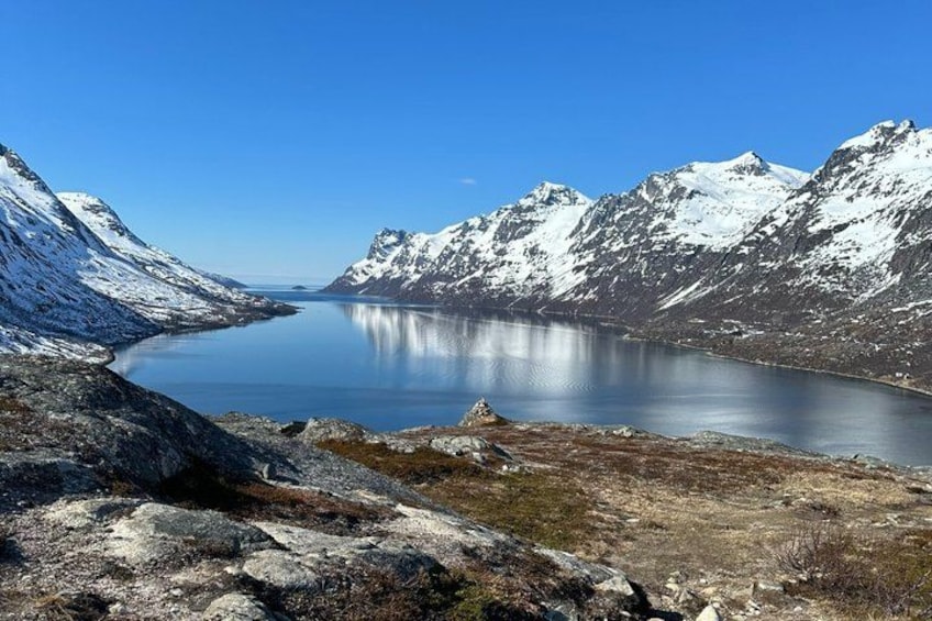 A mountainous landscape with a calm lake surrounded by snow-covered peaks. 2