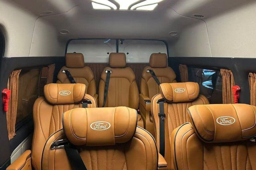A vehicle interior with tan leather seats and a sunroof. 5