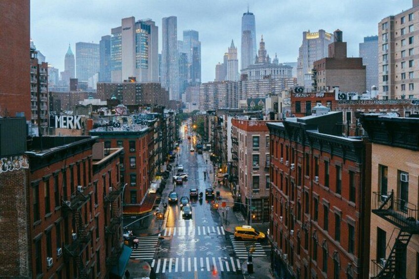 A city street with buildings, cars, and a yellow taxi. 2