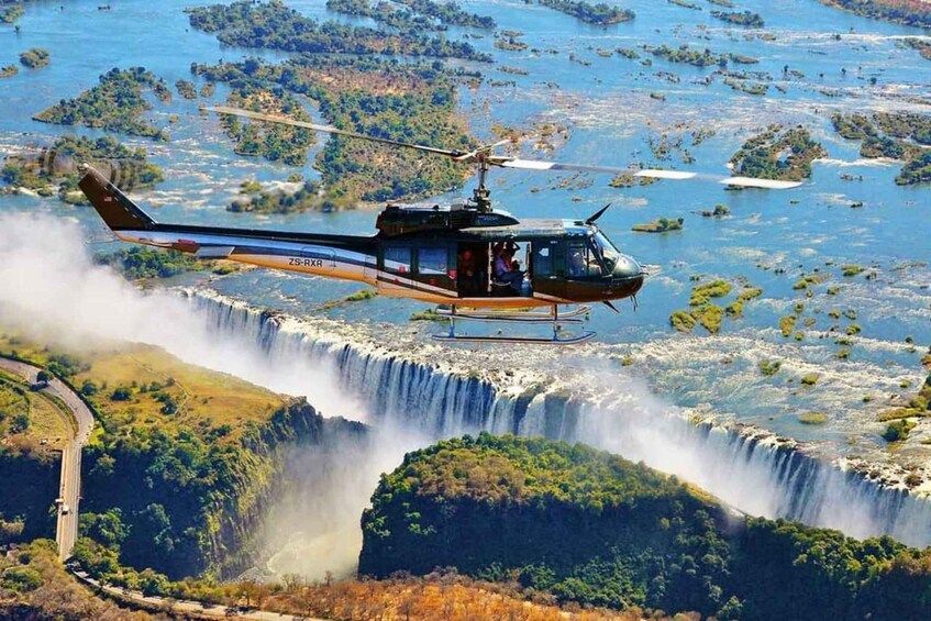 Helikopteri lentää vesiputouksen yllä. 5