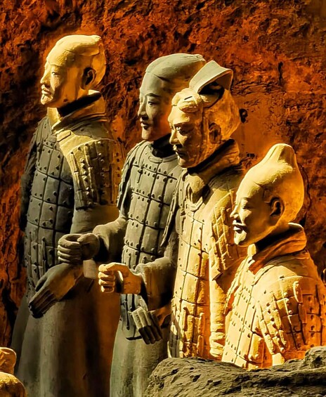 Una escultura de terracota con cuatro figuras vestidas con atuendo antiguo. 5