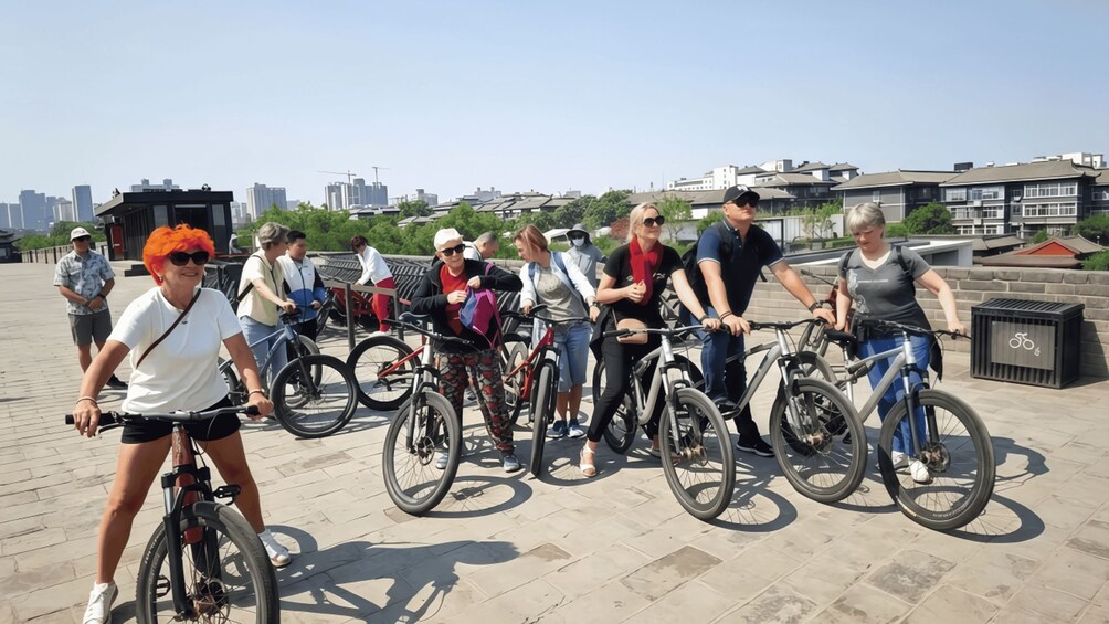 Un grupo de personas en bicicleta en un entorno urbano, con edificios al fondo. 3