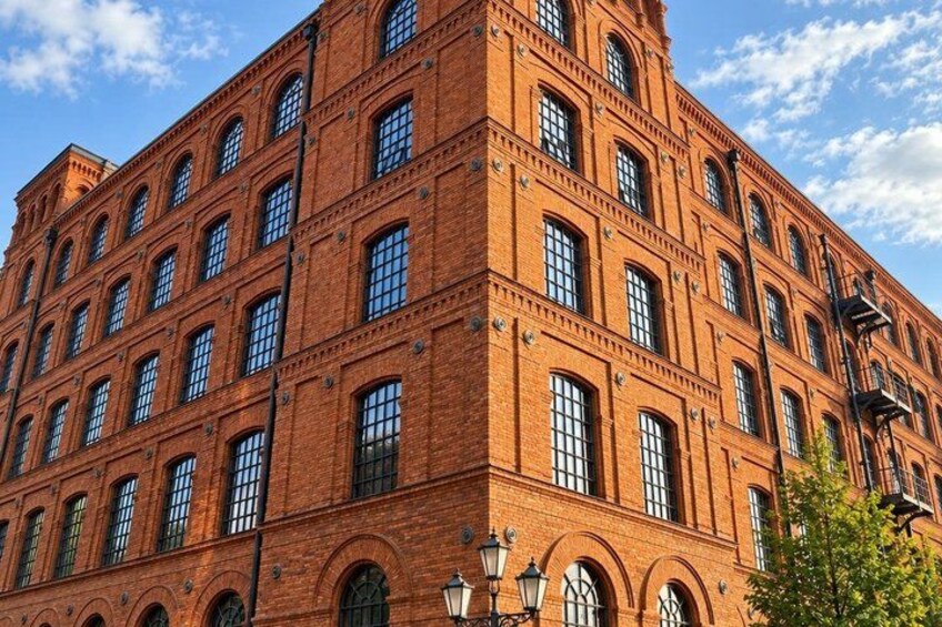 A red brick building with multiple windows and arched doorways. 3