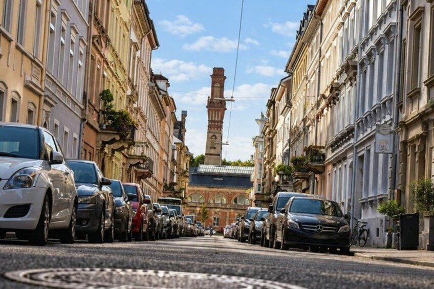 A street lined with parked cars and historic buildings. 2