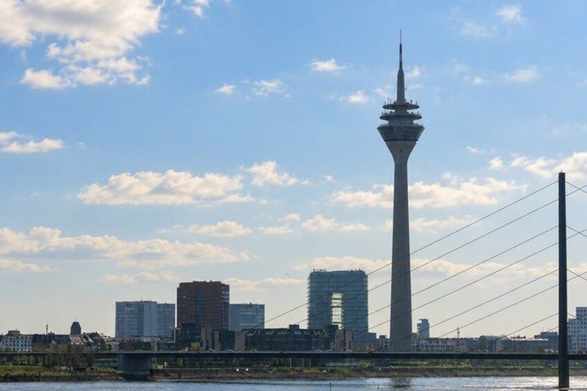 A city skyline with a prominent tower and several modern buildings. 3
