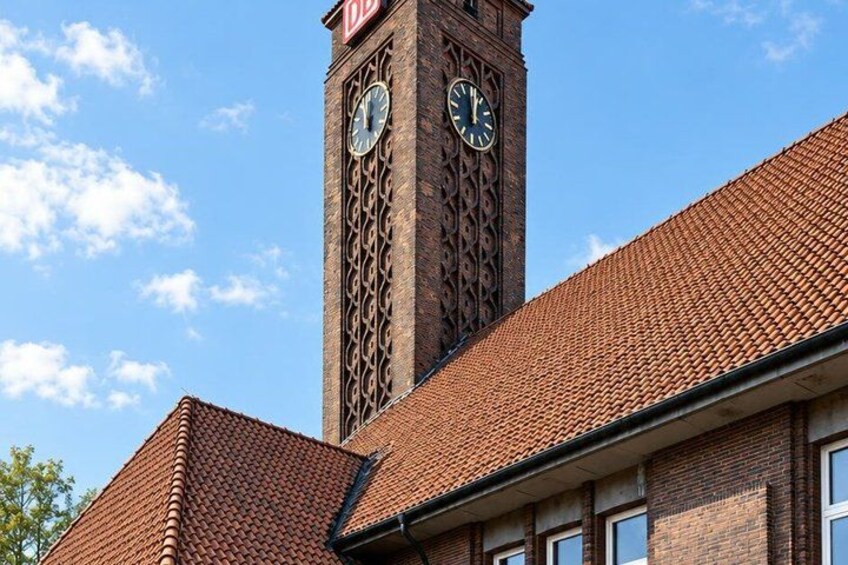 A building with a clock tower and a red-tiled roof. 5