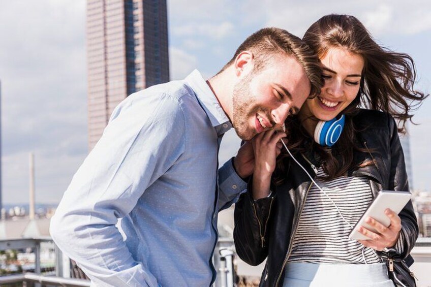 A couple standing on a rooftop with a cityscape in the background. 4