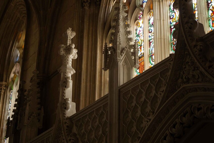 An ornate Gothic interior with intricate stone carvings and stained glass windows. 2