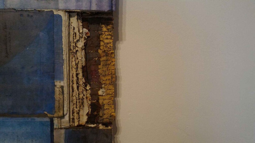 A wall with peeling paint and exposed layers of different colors. 5