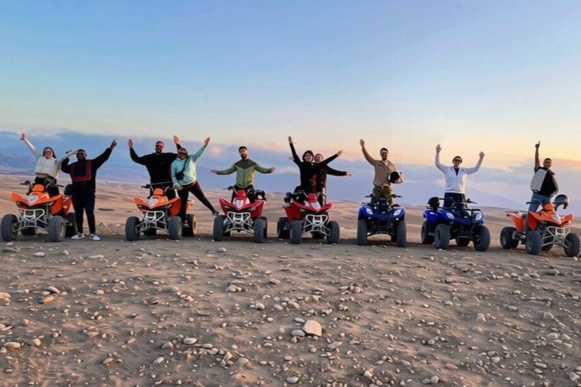 A group of people on quad bikes in a barren landscape with a clear sky. 3