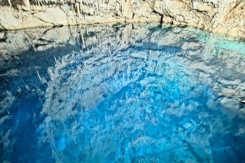 A clear blue pool with reflections of the surrounding rock formations. 1