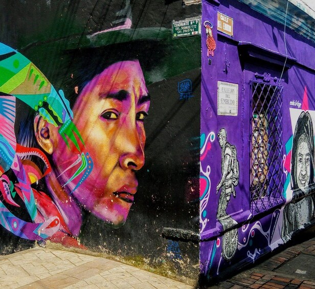 A colorful mural with a woman's face, a purple building with graffiti, and a street sign. 3