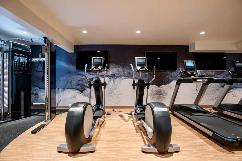 A gym with stationary bikes, treadmills, and weight machines. 5