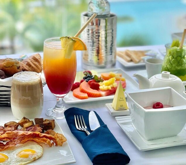 A breakfast setting with a table, food, drinks, and a view. 3