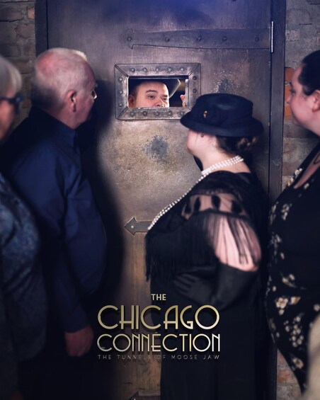 A group of people standing in front of a metal door with a small window. The text 'THE CHICAGO CONNECTION' is visible. 5