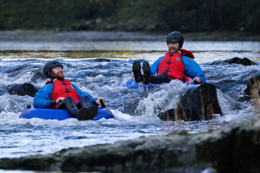 Two people rafting on a river with rapids. 3