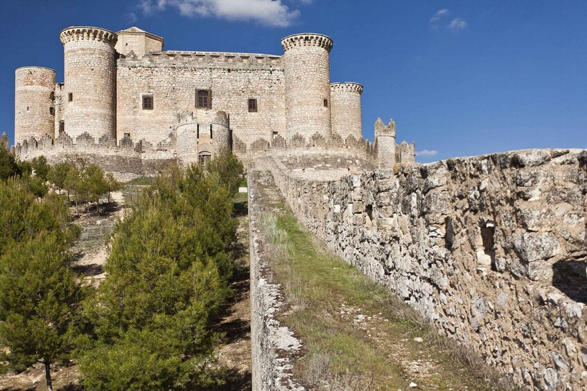 A historic stone castle with multiple towers and a fortified wall. 3