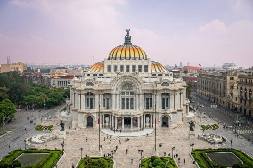 A large, ornate building with a golden dome, surrounded by a spacious plaza with trees and a fountain. 4