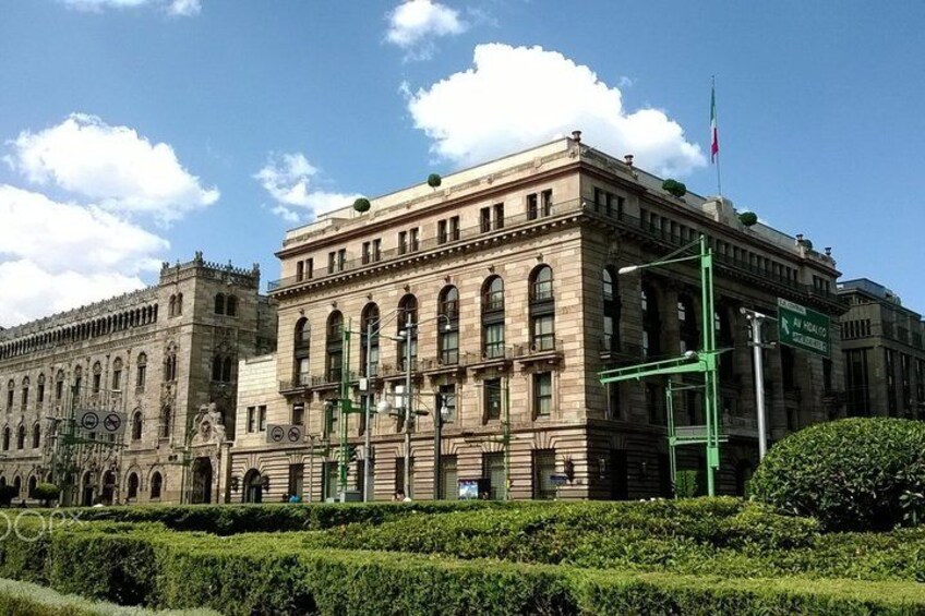 A large historic building with arched windows and a flagpole. 2