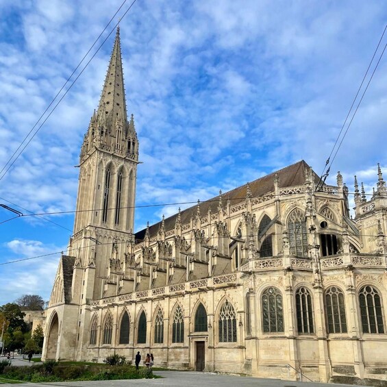 Una catedral histórica con una aguja alta, intrincados trabajos en piedra y grandes ventanales de arco. 4