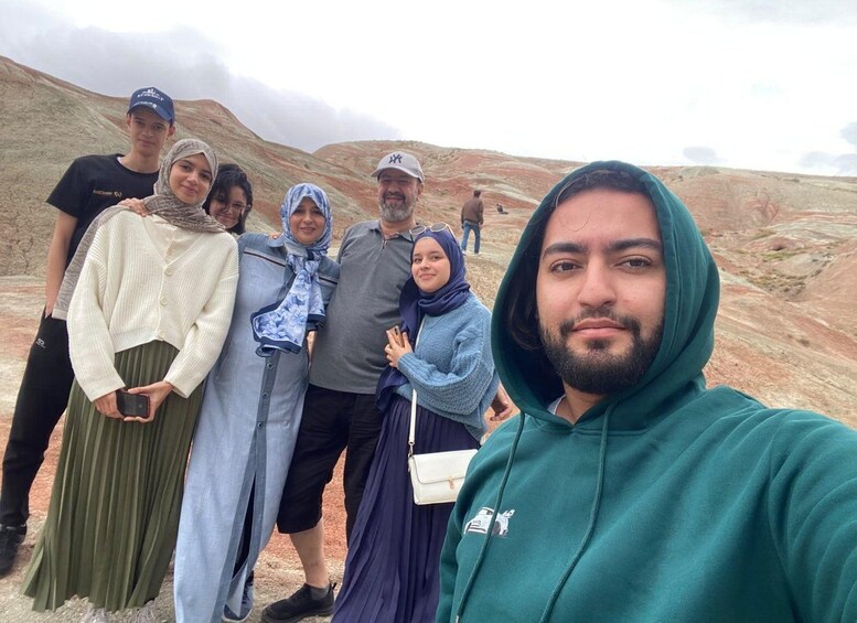 A group of people standing on a rocky hillside with a cloudy sky. 5