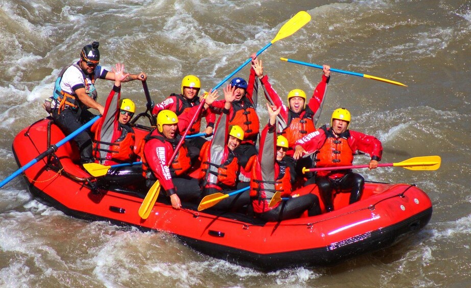 A group of people in a red inflatable raft on a river. 5