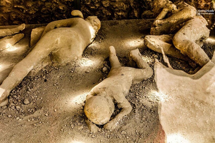 Alte Steinstatuen von menschlichen Figuren, die am Boden liegen. 2