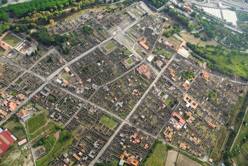 Eine Vogelperspektive auf ein dicht bebautes Stadtgebiet mit einem Schachbrettmuster aus Straßen und Gebäuden. 3