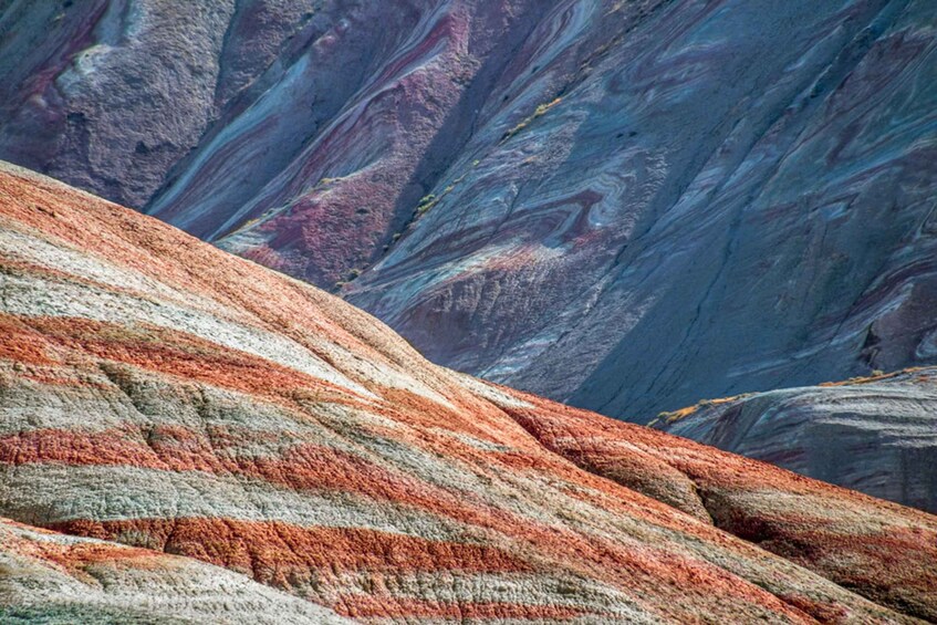 A mountain with layered rock formations in shades of red, orange, and gray. 1