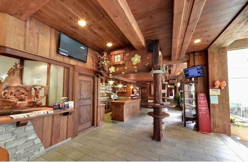 A wooden interior with a bar area, wooden ceiling, and a large wooden sculpture. 4