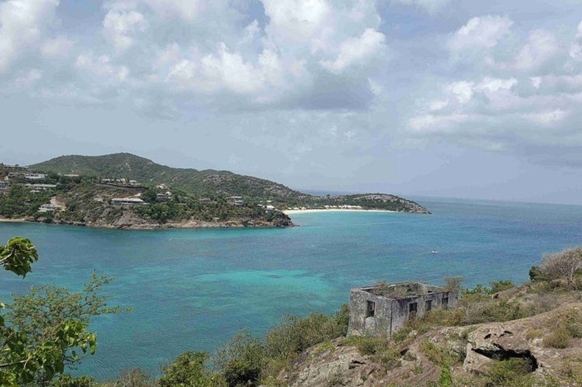 A coastal landscape with clear turquoise waters, a small island with buildings, and a rocky foreground. 3