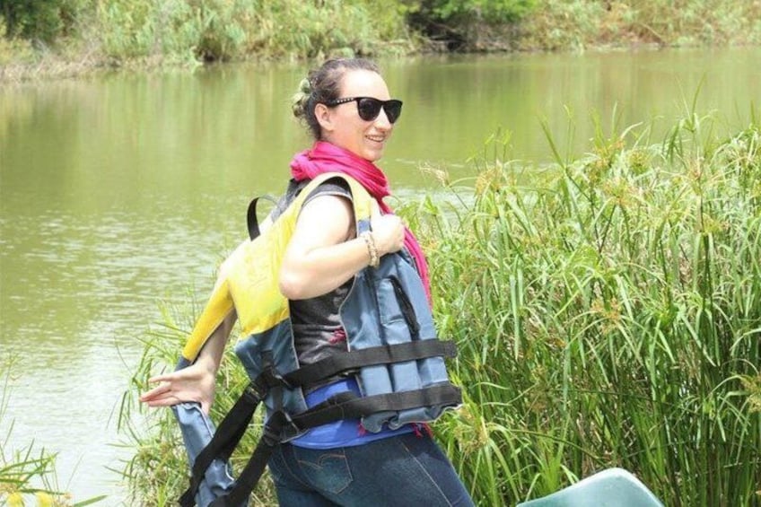 A person walking near a body of water with tall grass and reeds. 3