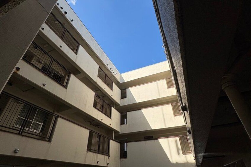 A multi-story building with balconies and barred windows. 5
