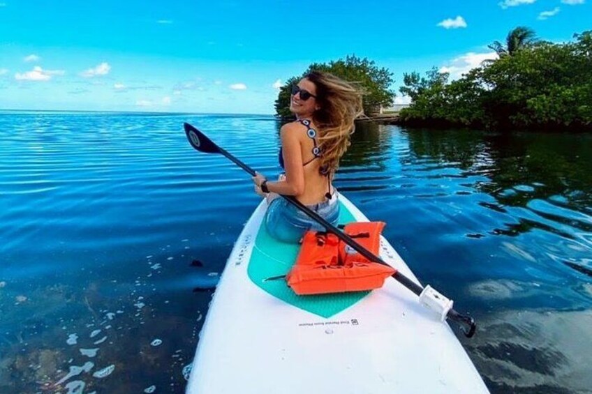 A person kayaking on calm water with greenery in the background. 3