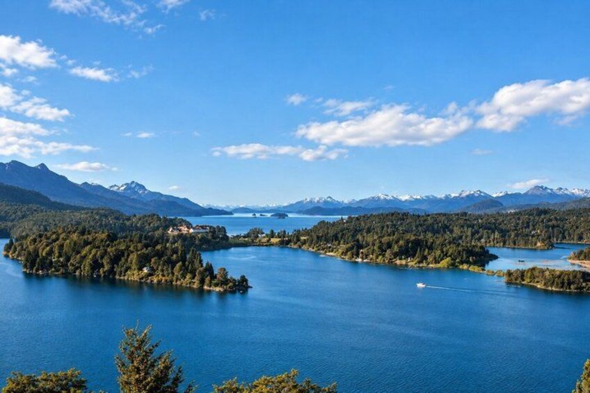 A lake surrounded by forested islands and mountains. 2