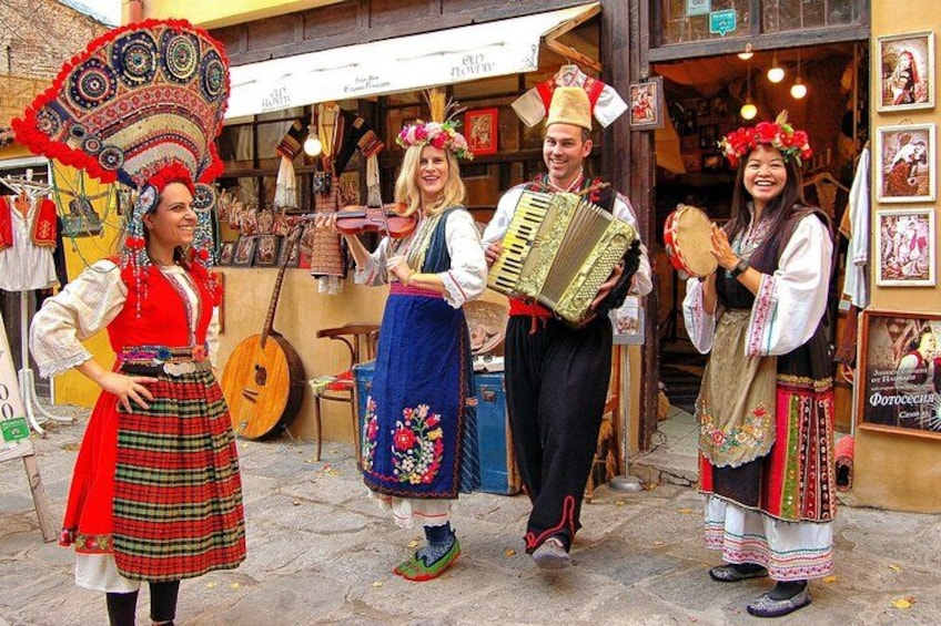 A street scene with people in traditional attire, a guitar, and a shop with various items on display. 1