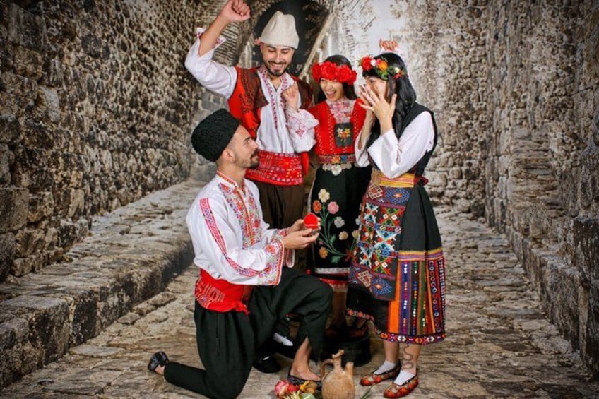 A group of people in traditional attire, standing on a stone pathway. 4
