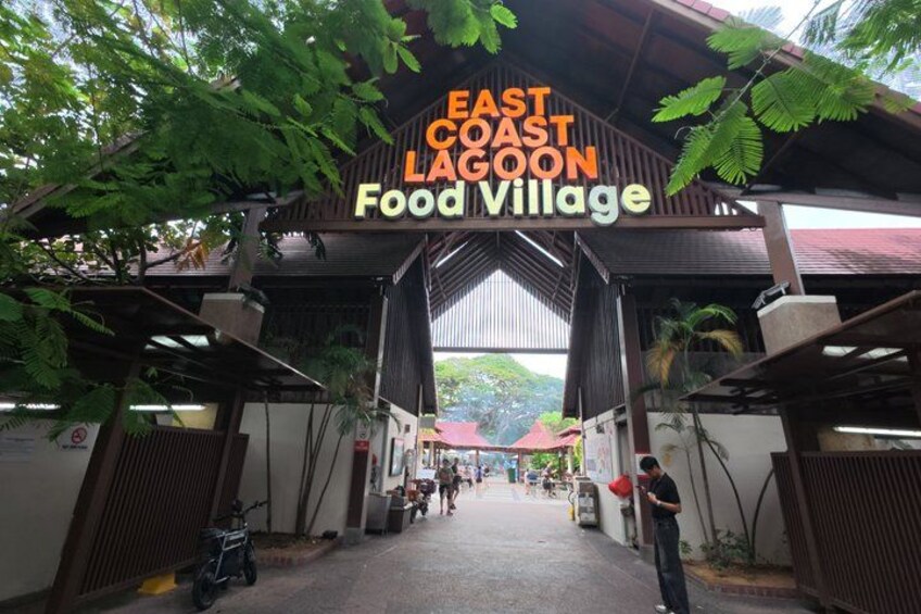 The entrance to East Coast Lagoon Food Village with a covered walkway and a sign. 5