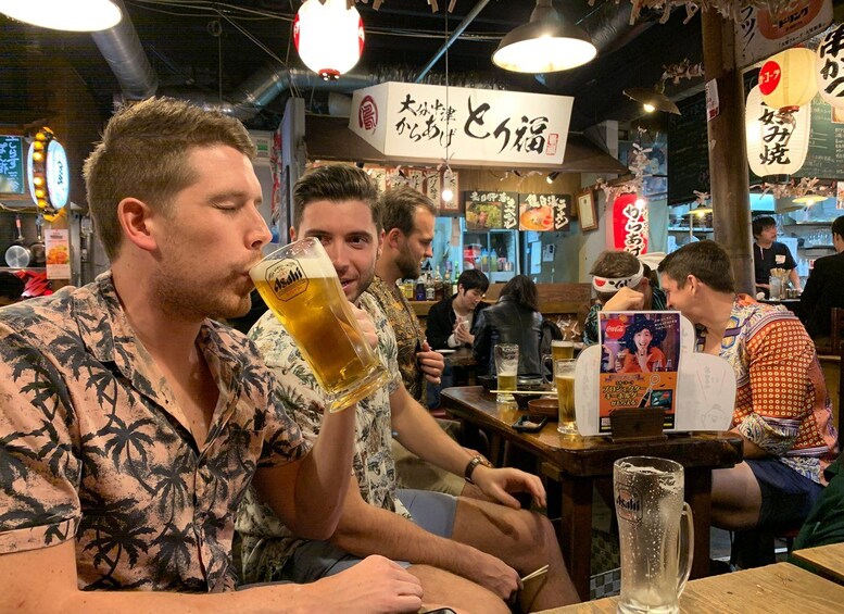 Interior de un restaurante con clientes sentados en mesas, algunos sosteniendo bebidas. 3