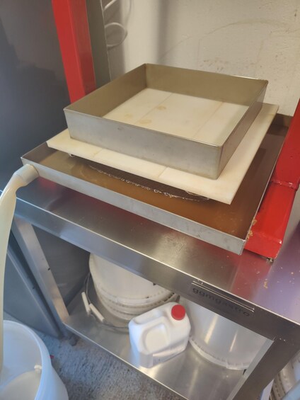 En metalbakke med en hvid overflade, muligvis et skærebræt, på et stålbord. 4