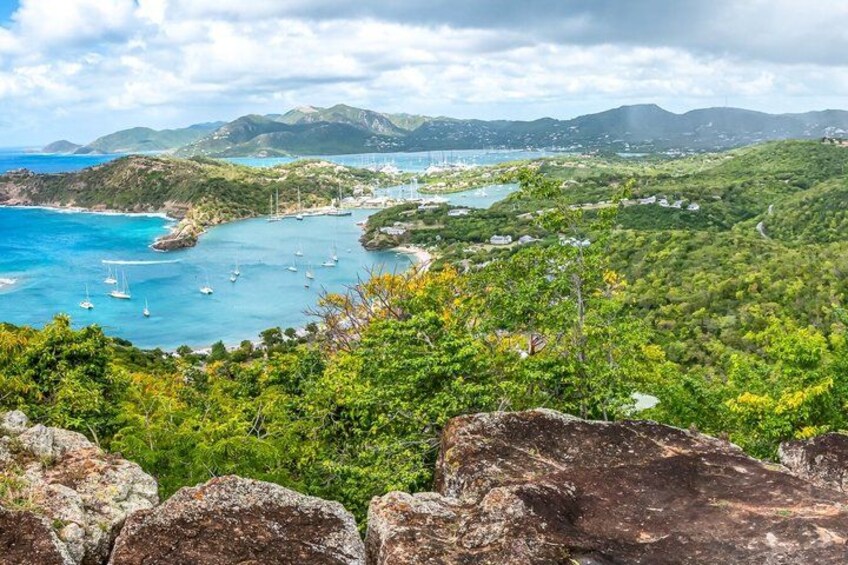 A coastal landscape with a bay, boats, and lush greenery. 4