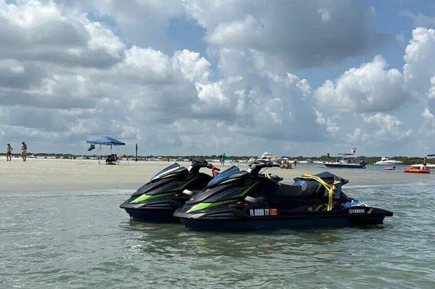 Two jet skis on a beach with a cloudy sky. 5