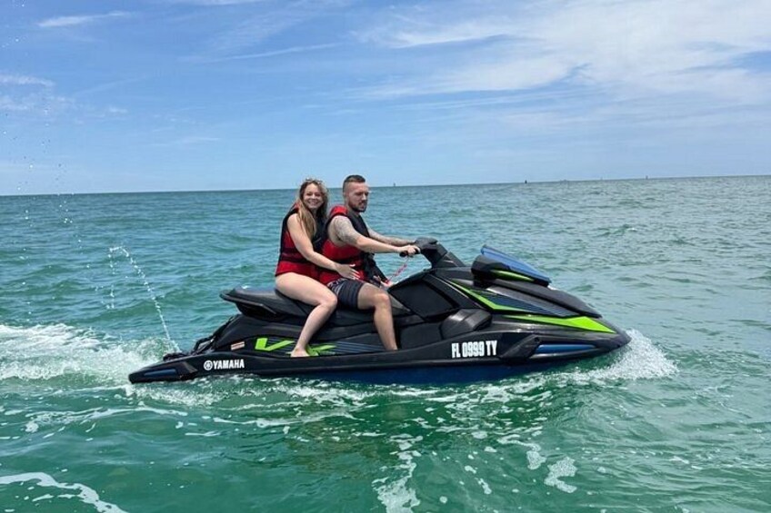 Two people on a jet ski with the text 'YAMAHA' and 'H. 0999 TY' on the side. 3