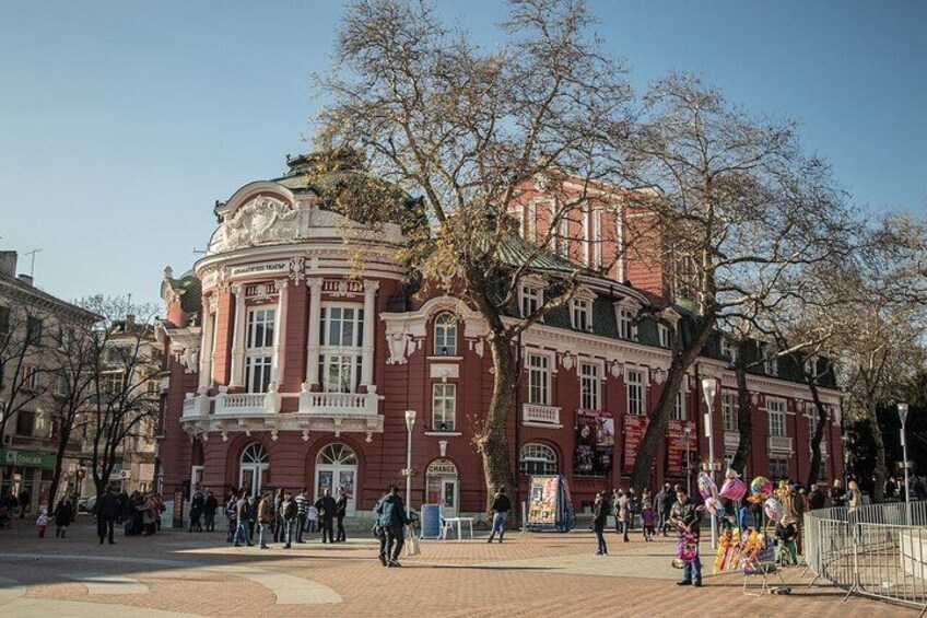 A historic building with ornate architecture, a central open plaza, and leafless trees. 5