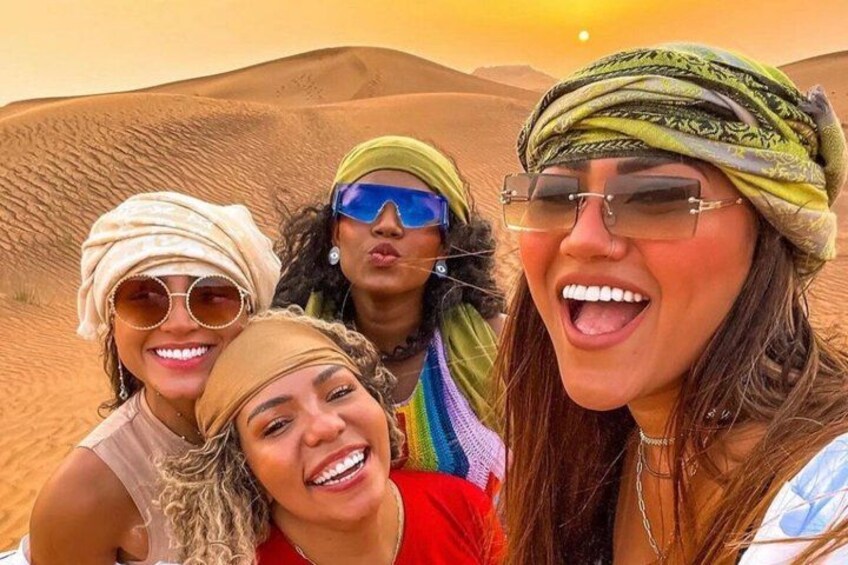 Four people in a desert landscape with sand dunes. 3