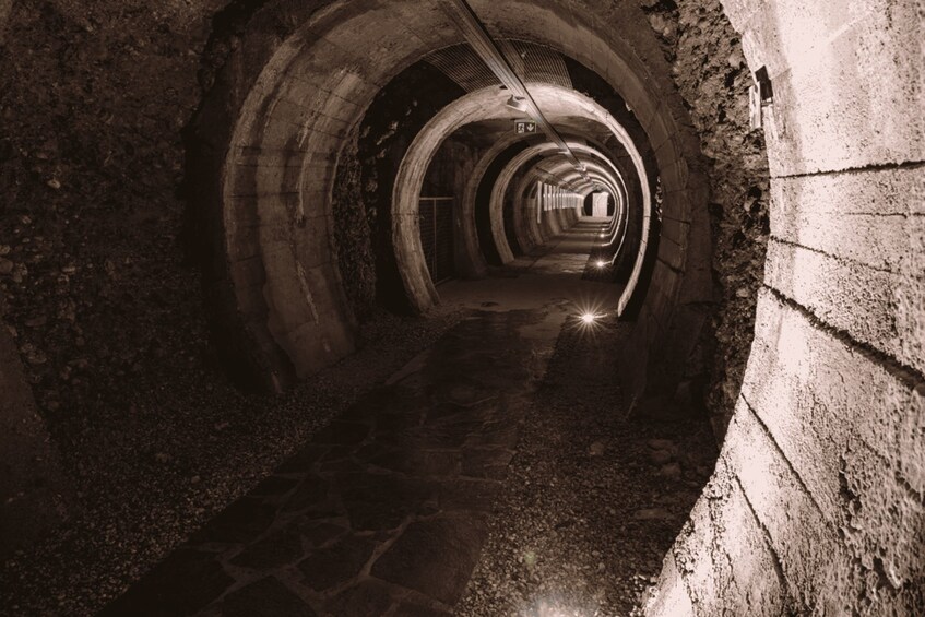 A tunnel with arched ceilings and a cobblestone path. 2