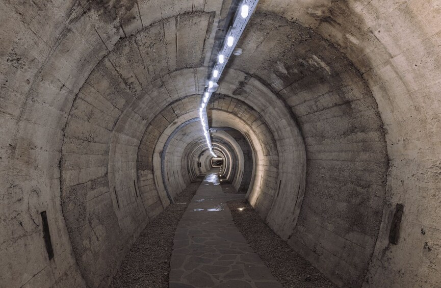 A tunnel with concrete walls and a paved path. 3